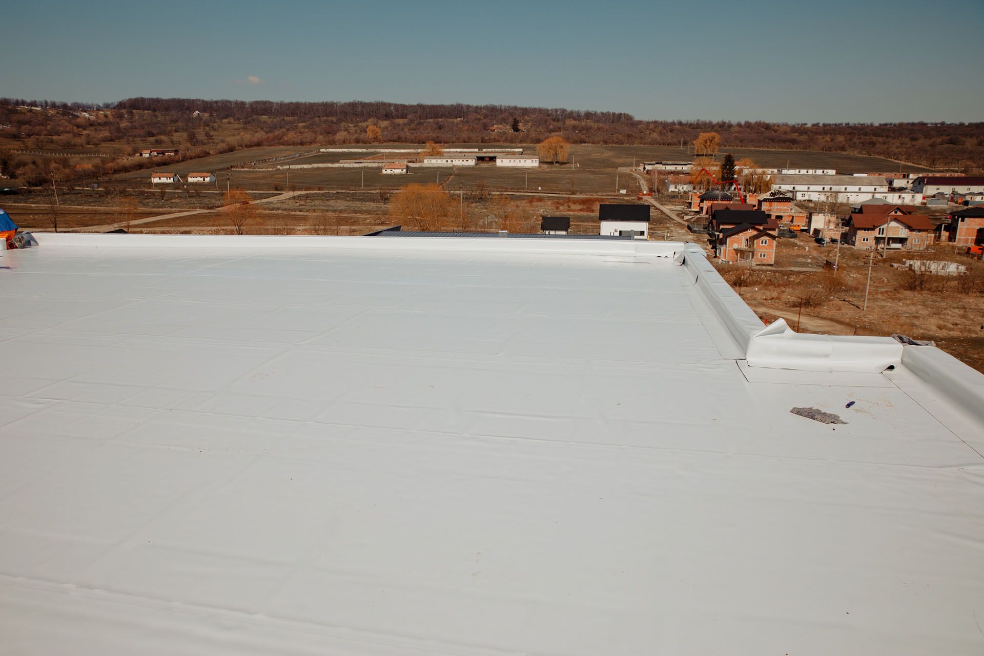 White flat roof of a building with rural background