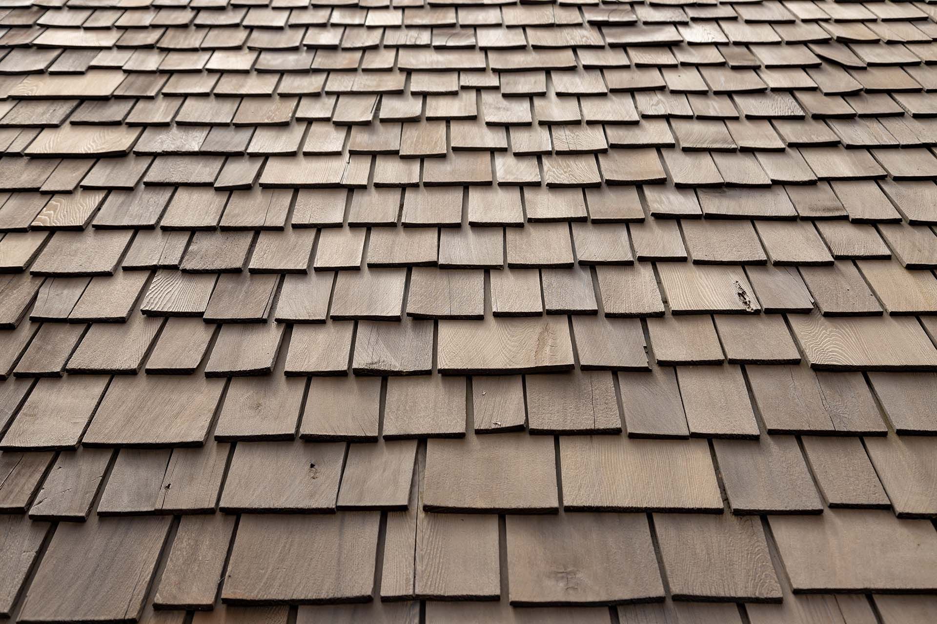 Wooden shake roof, showing overlapping rows of brown, weathered wood tiles