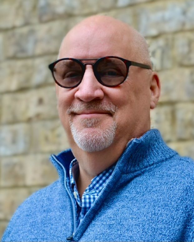 A close up of a man wearing glasses and a beard.