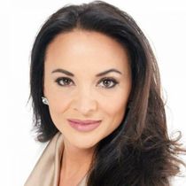 A woman with long dark hair is smiling for the camera