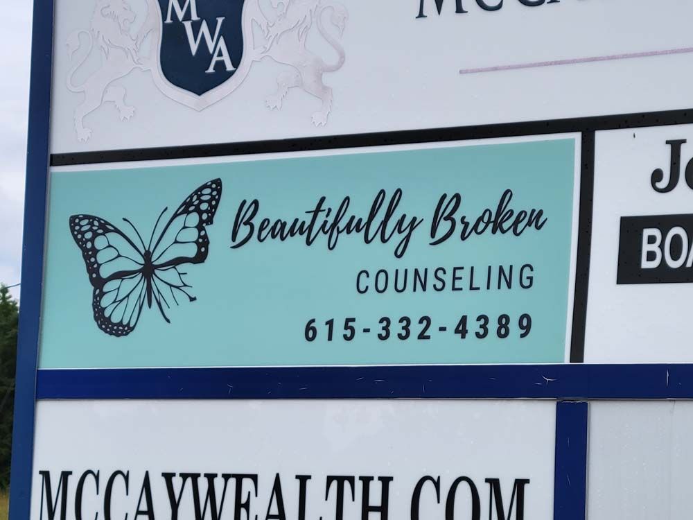 A sign for beautifully broken counseling has a butterfly on it