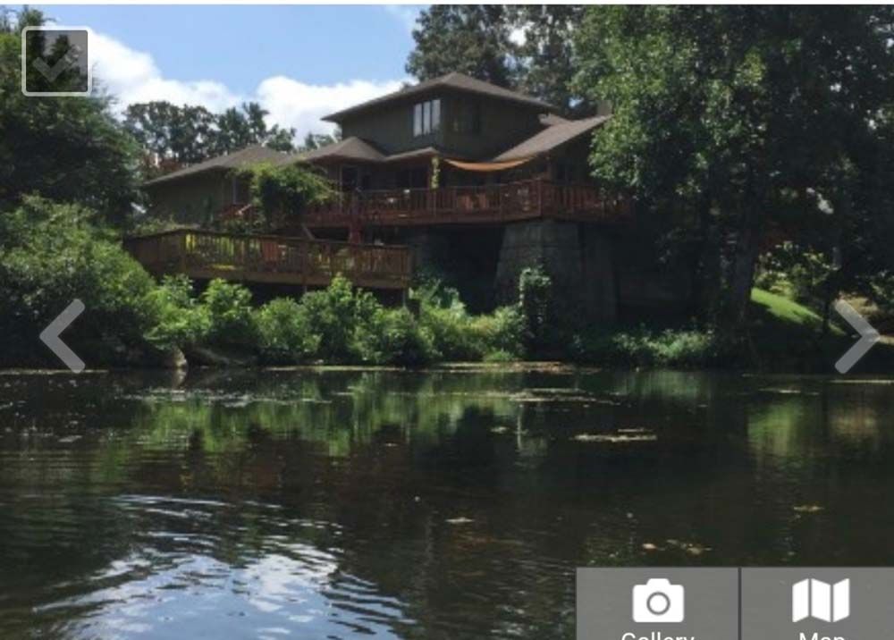 A large house sits on the shore of a lake