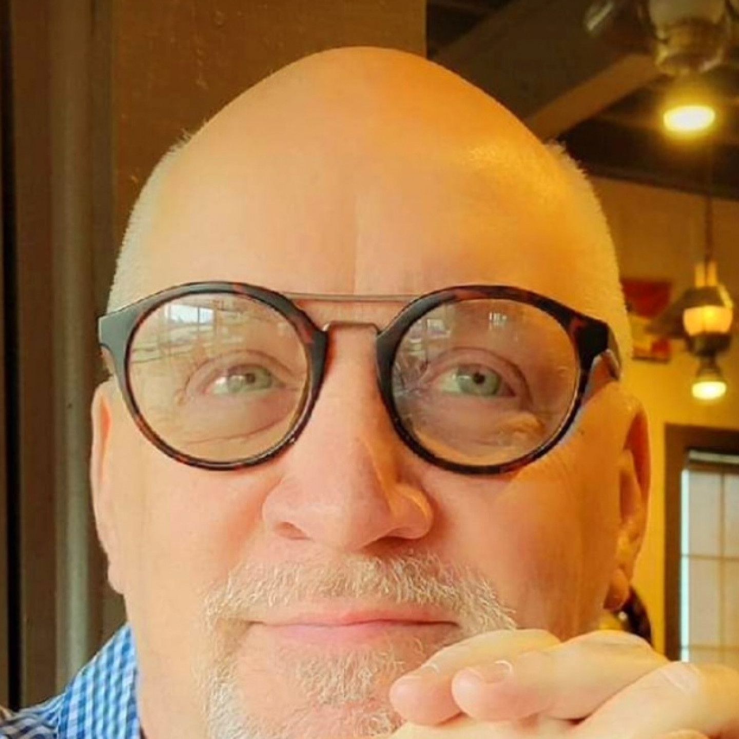 A close up of a man wearing glasses and a beard.