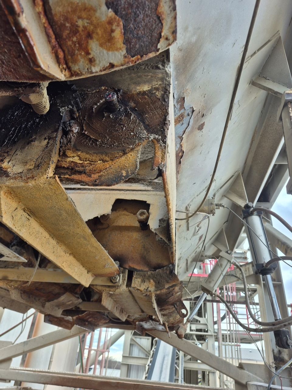Severe rust and corrosion on industrial equipment; metal beams with peeling paint and dark stains
