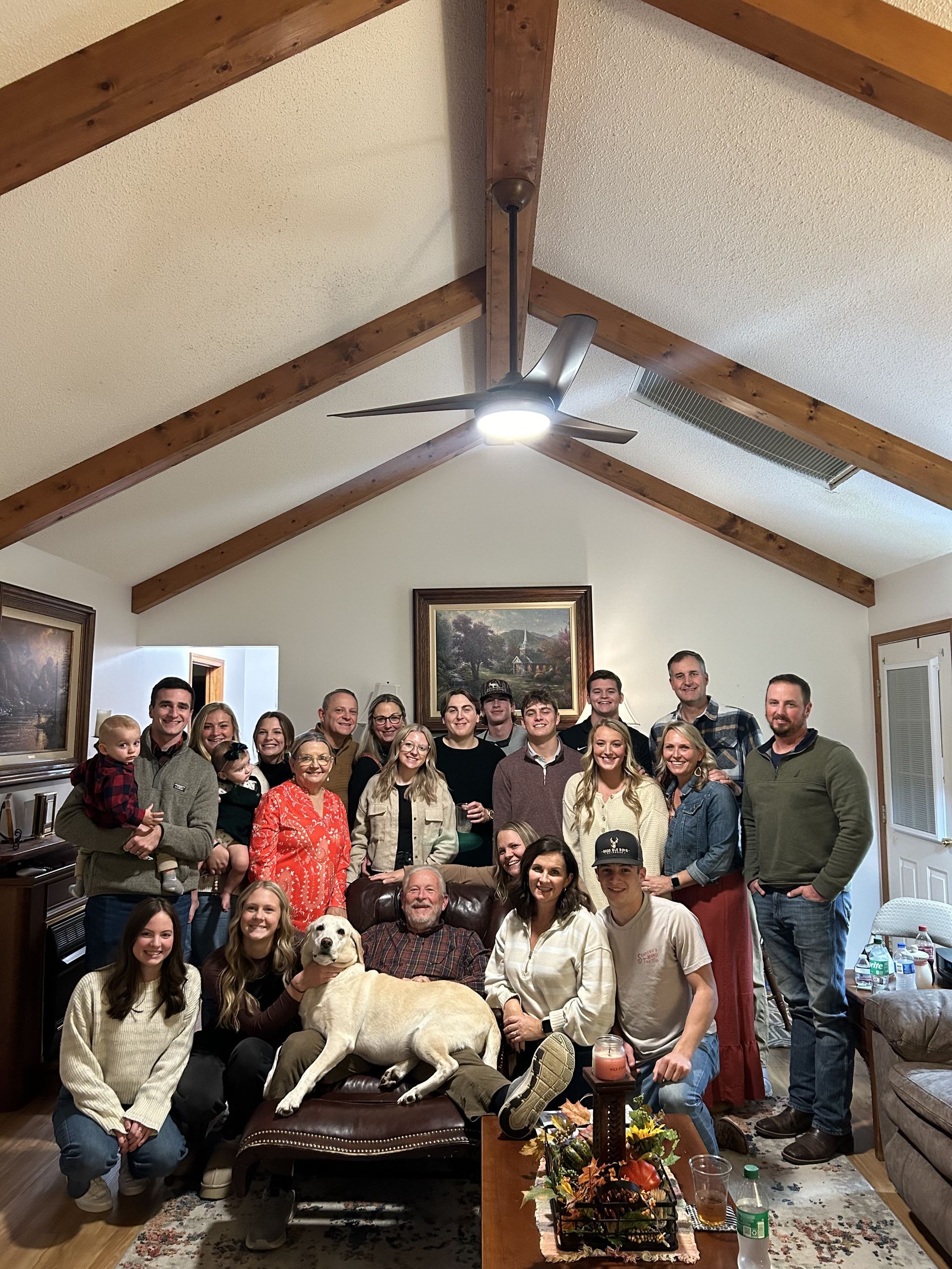 A large group of people are posing for a picture in a living room.
