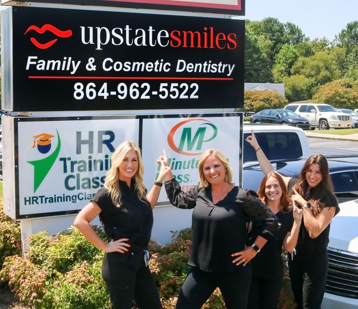 Upstate Smiles team pointing at street sign