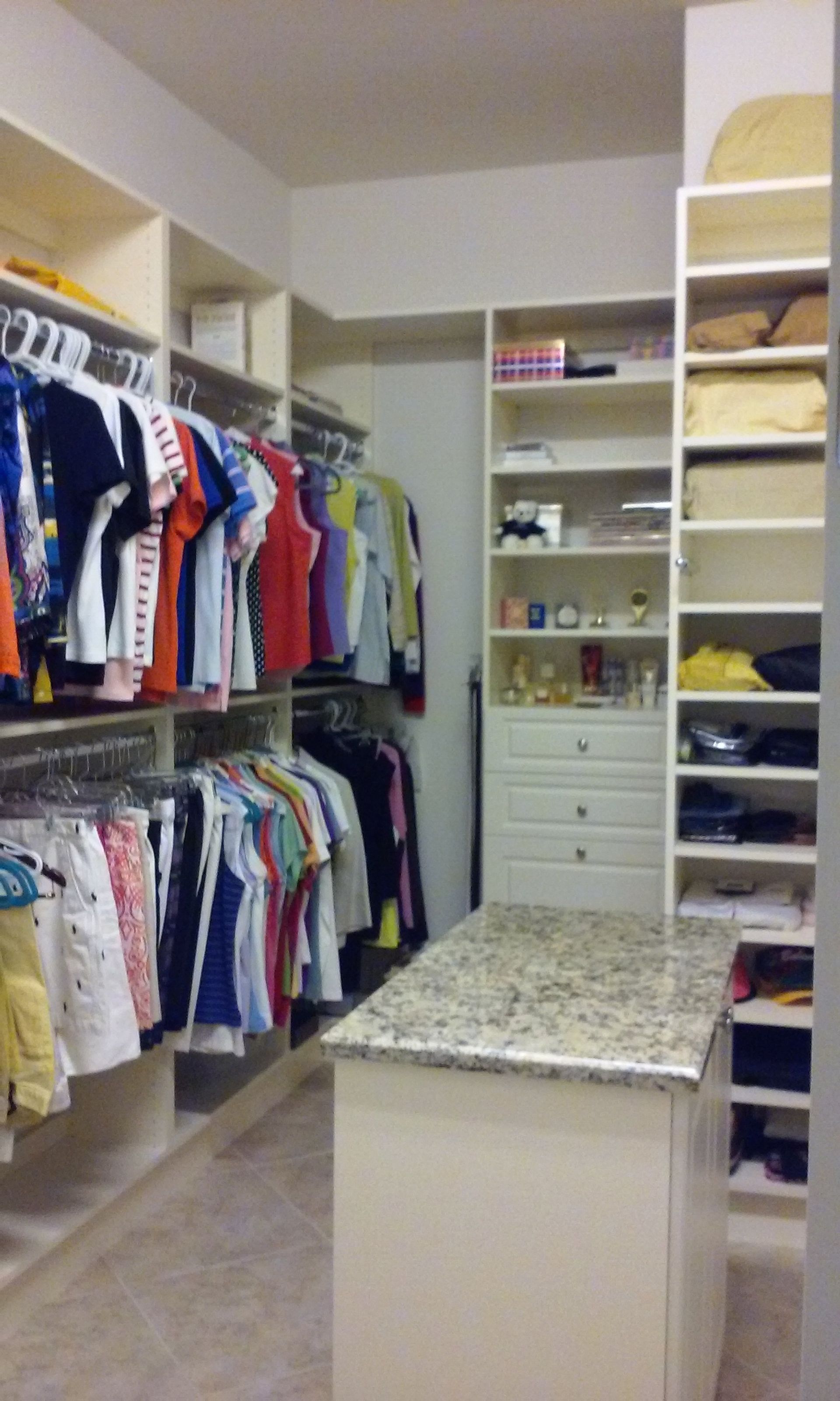 A walk in closet filled with clothes and a table