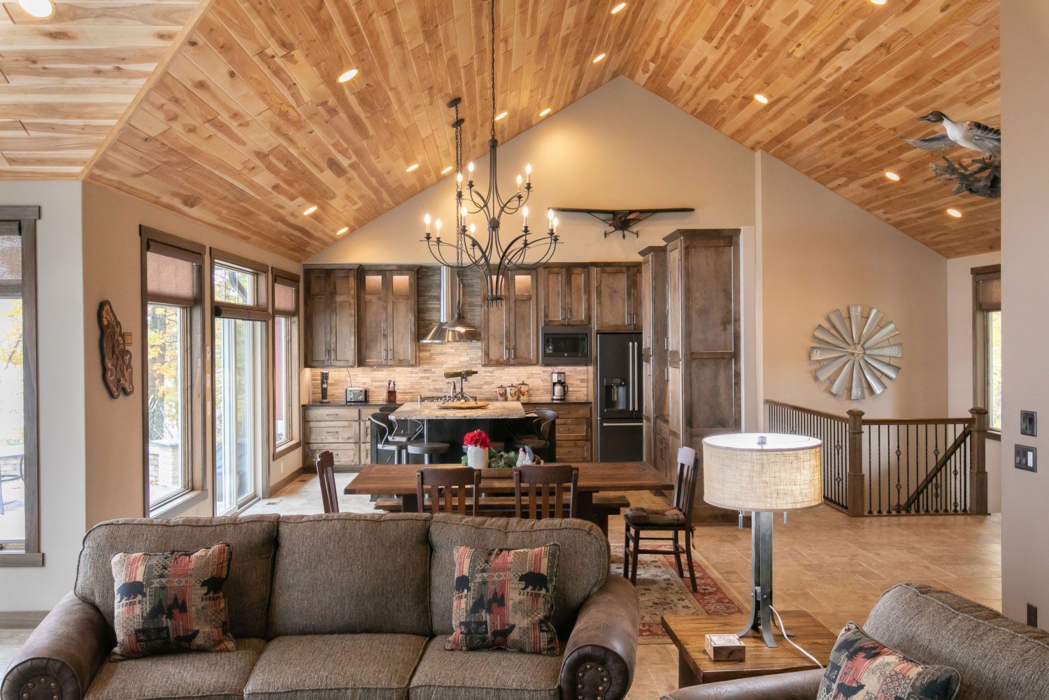 A living room with a couch , chairs , a table and a chandelier.