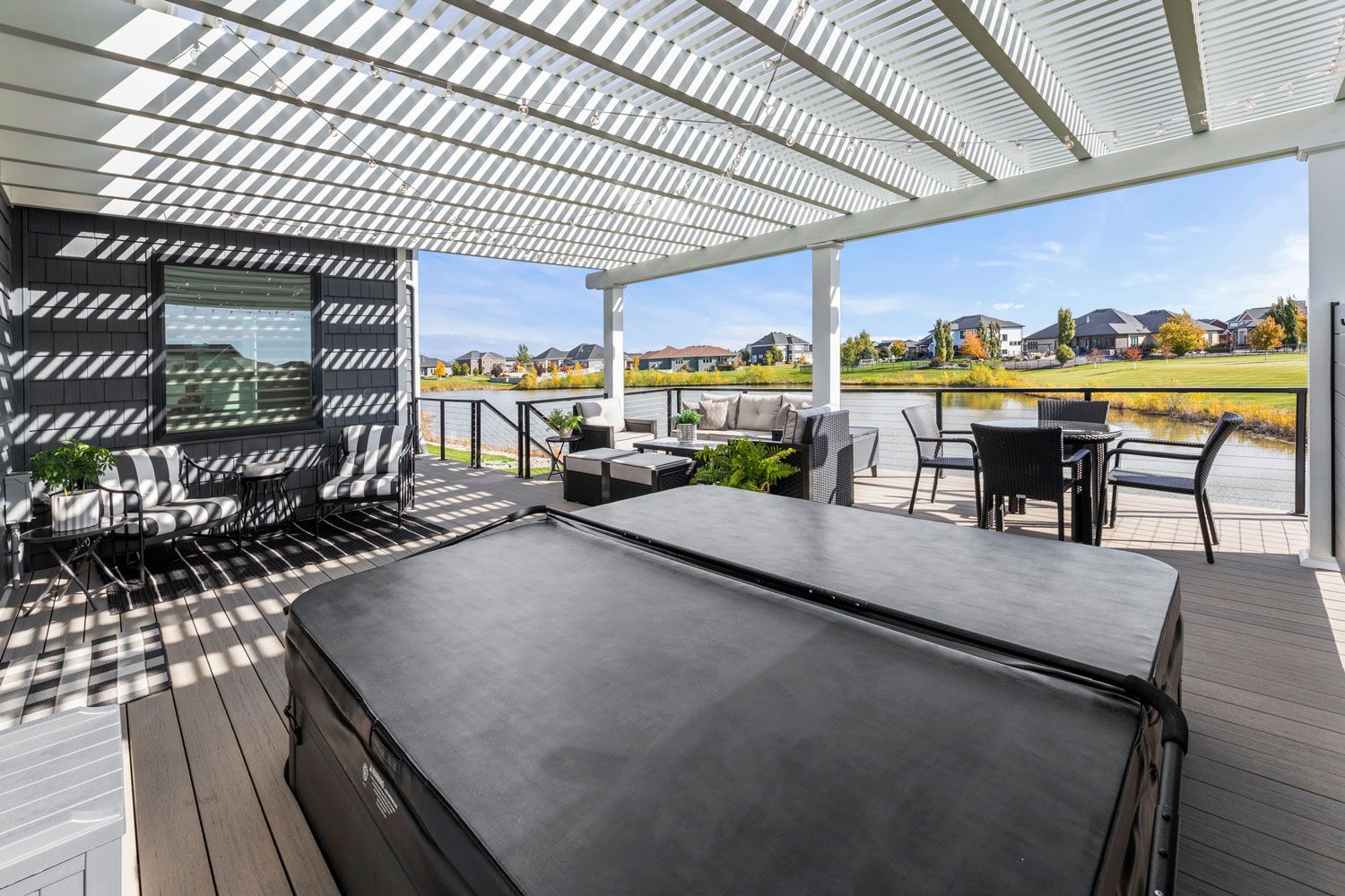 A hot tub is sitting under a pergola on a patio.
