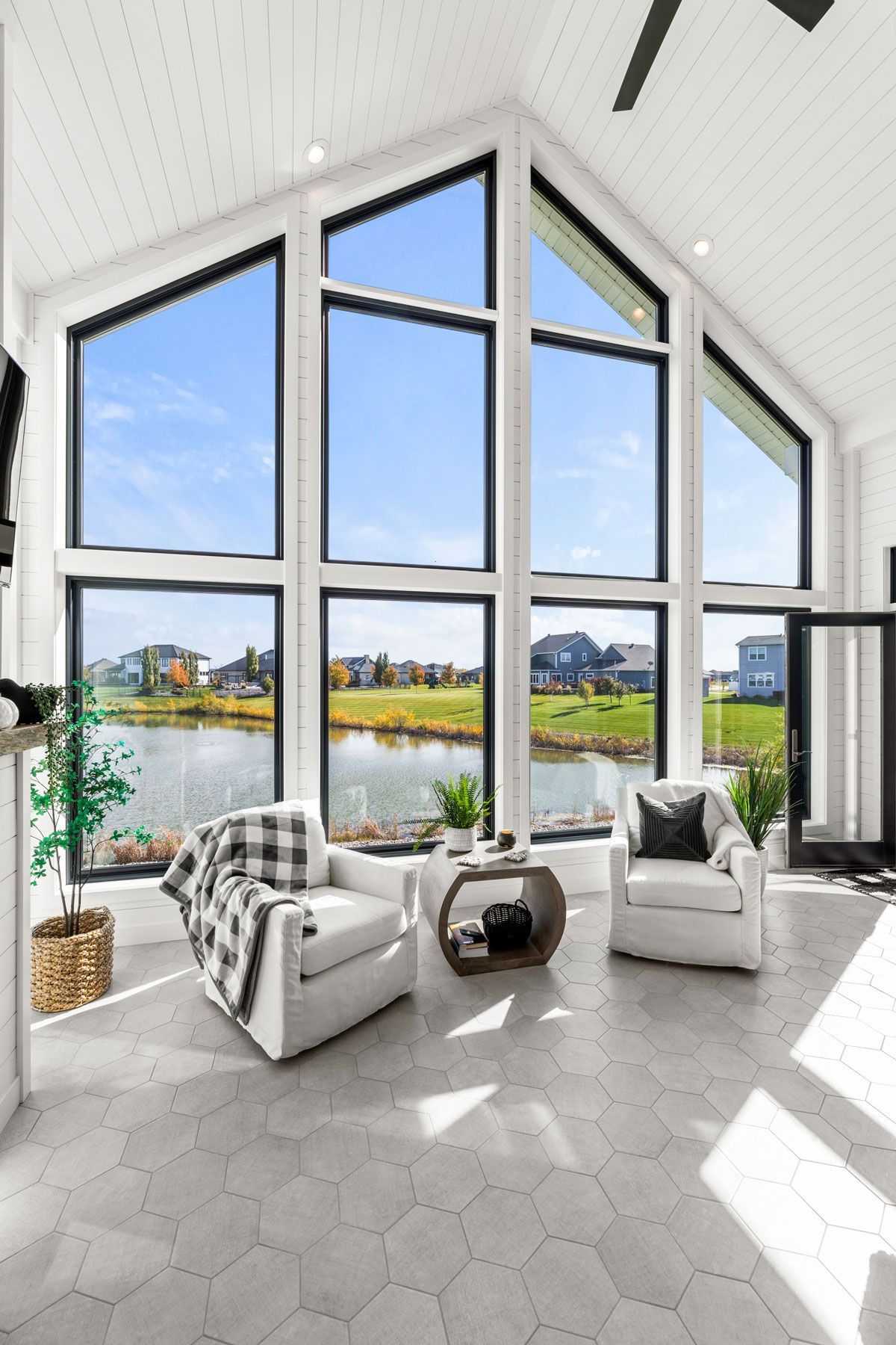 A living room with a lot of windows and chairs