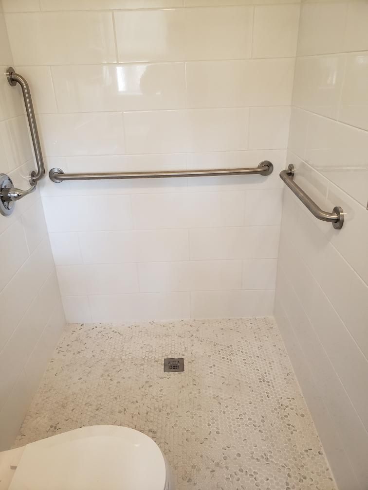 White accessible shower with grab bars.
