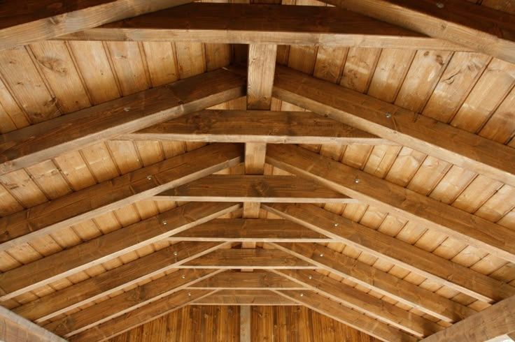 Wooden roof structure with rafters and beams.