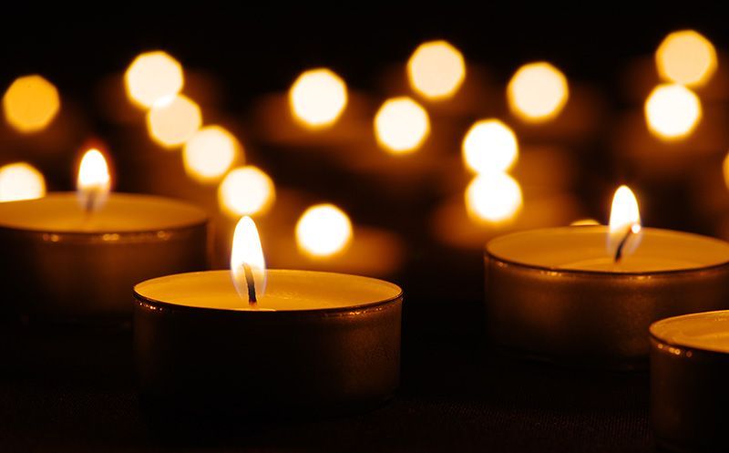 A group of lit candles in a dark room.