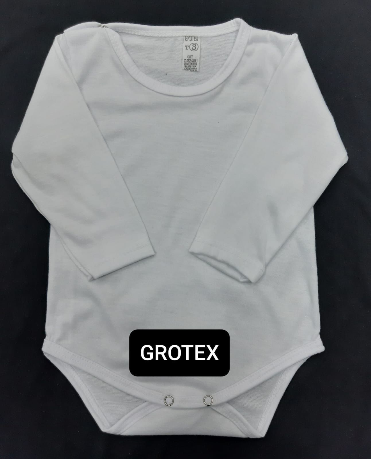 Un mono blanco de bebé con mangas largas está etiquetado como Grotex.