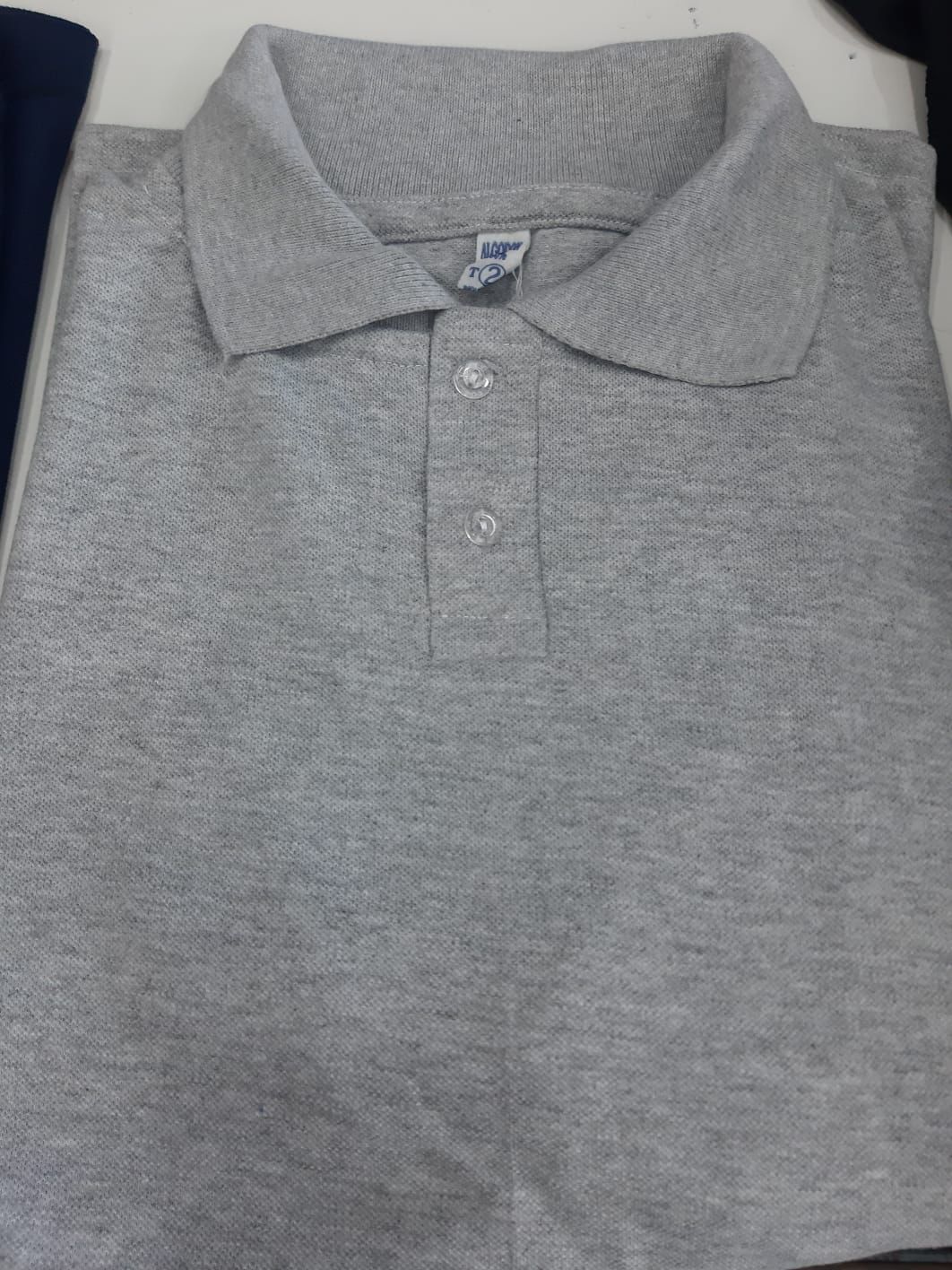 Un primer plano de un polo gris sobre una mesa.