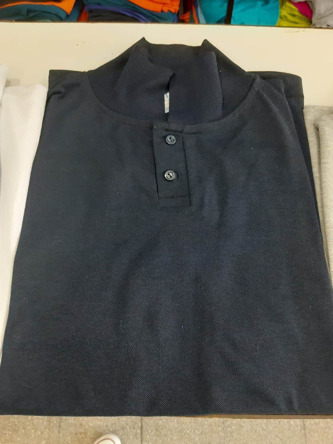 Un primer plano de un polo gris sobre una mesa.