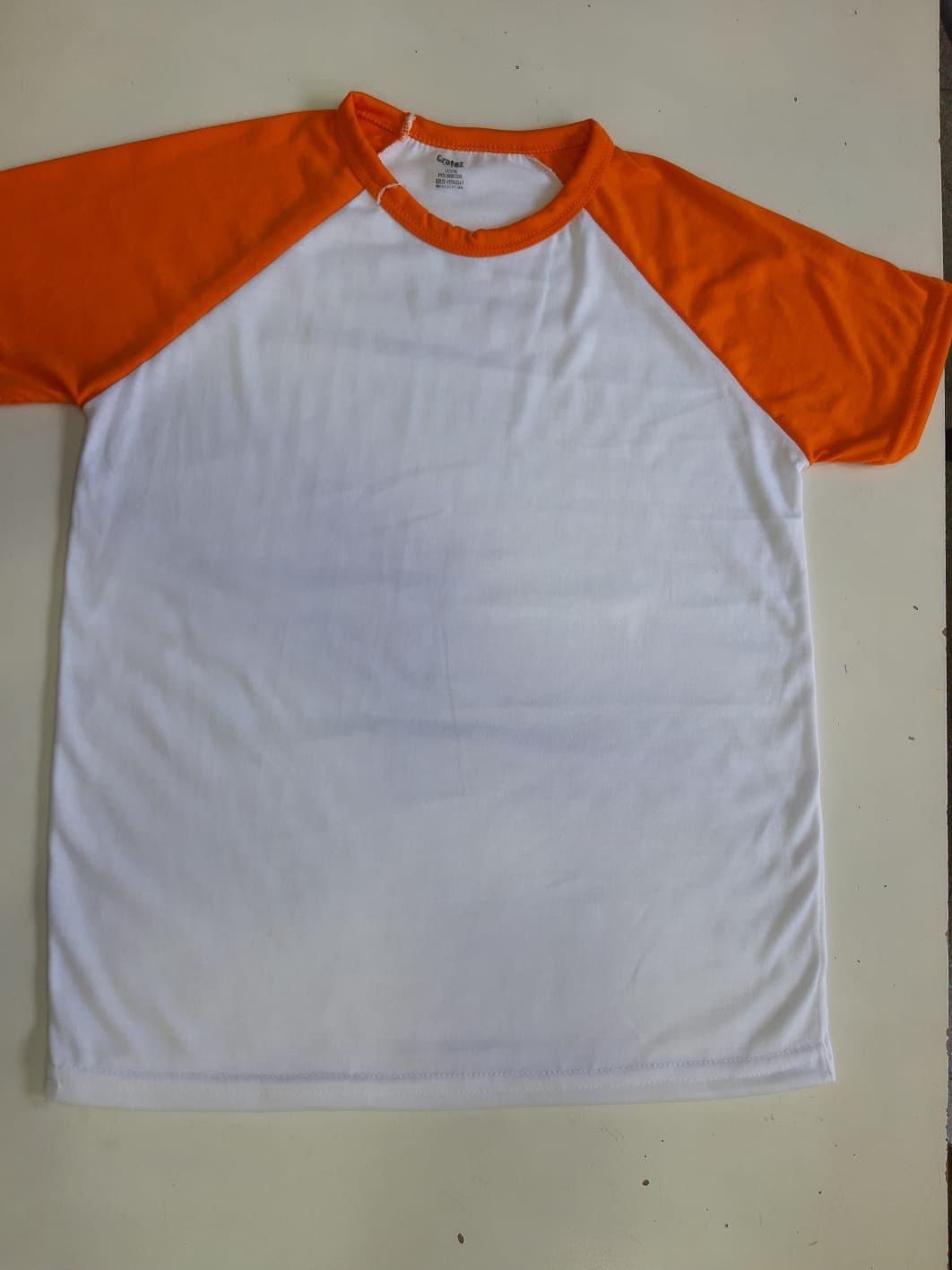 Una camiseta blanca con mangas rojas está sobre una mesa