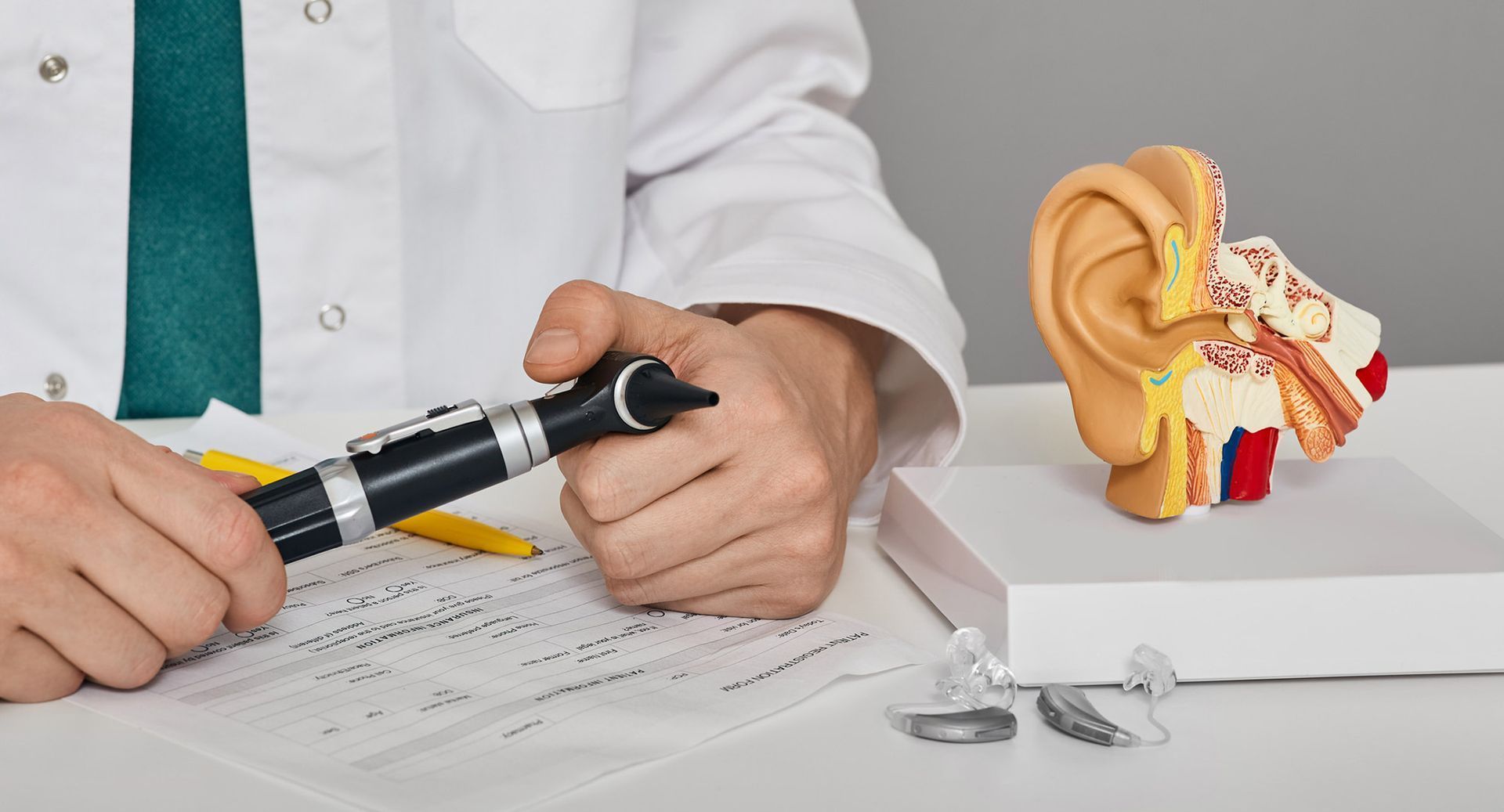 otorino davanti a un plastico della cavità uditiva