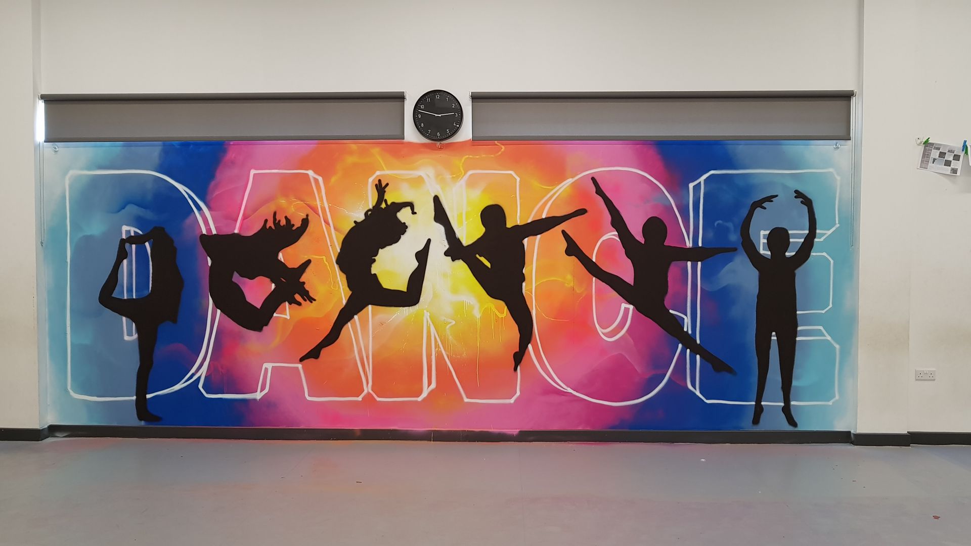 Wall art: "DANCE" in large letters, with dancers silhouetted over colorful background in a dance studio.