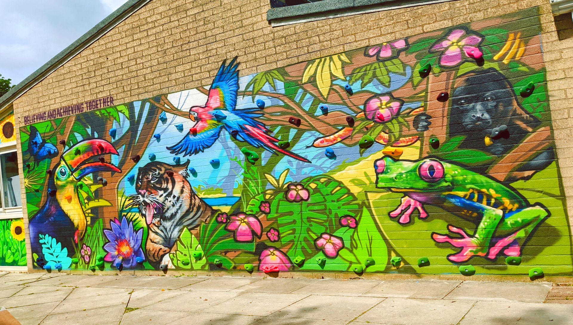 Colorful mural of jungle animals: parrot, tiger, frog, and monkey in a lush green setting.