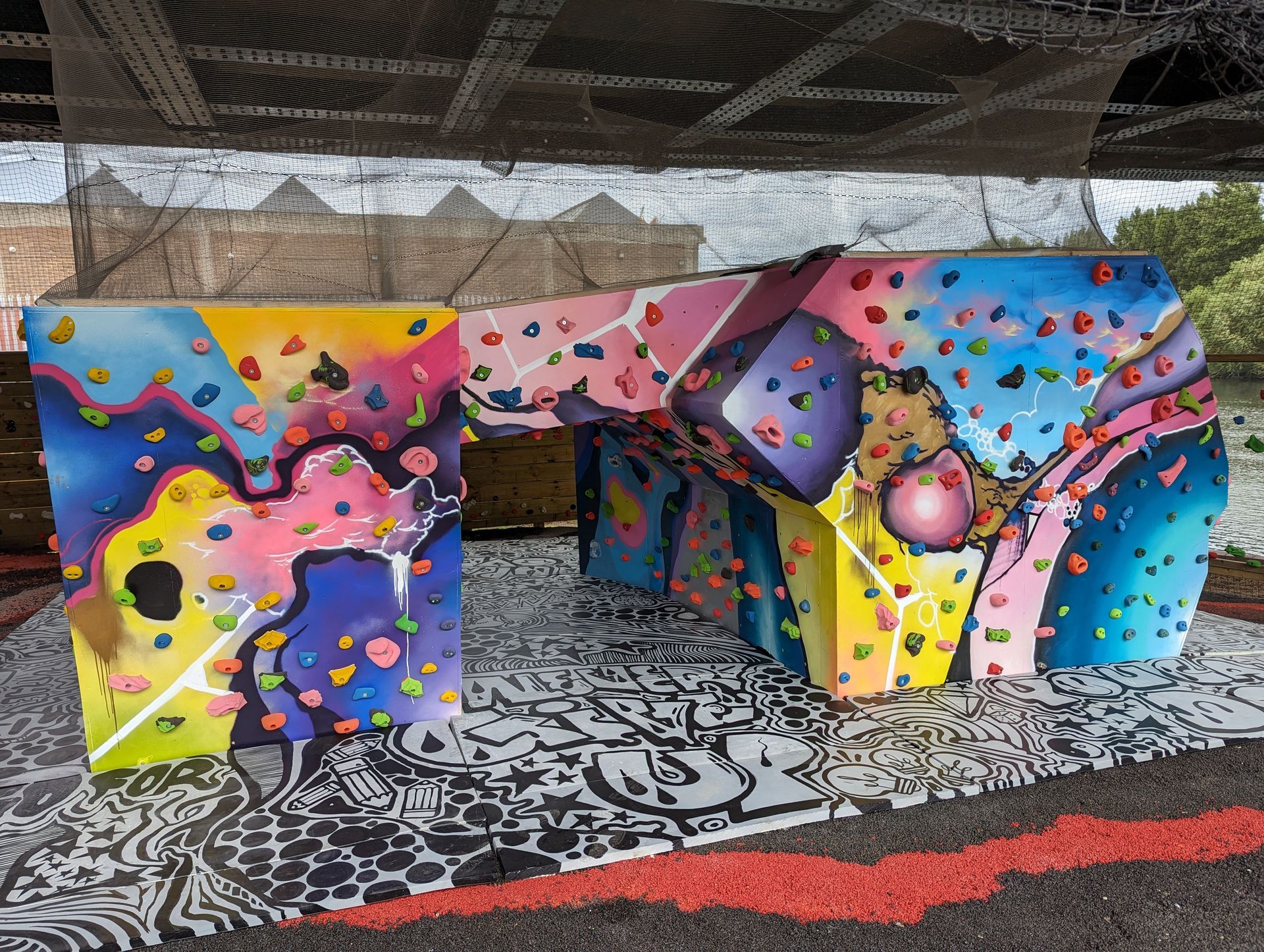 Colorful climbing wall structure with various holds, outdoors.