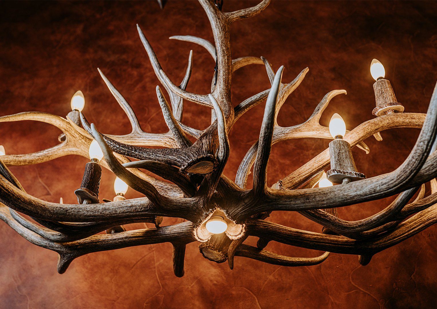 A chandelier made of deer antlers is hanging from the ceiling.