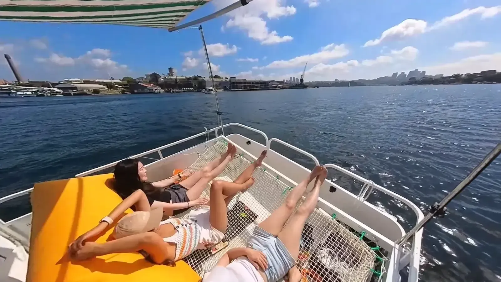 A group of people are laying on a boat in the water.