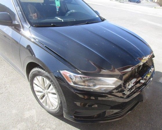A black car with a damaged hood is parked on the side of the road. Auto Body Repair in Colville, WA