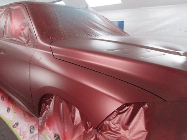 A red car is being painted in a garage. Auto Body Repair in Colville, WA