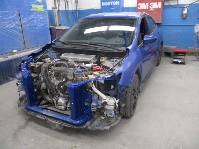 A blue car with the front end removed is in a garage. Auto Body Repair in Colville, WA