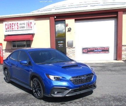A blue car is parked in front of a car dealership. Auto Body Repair in Colville, WA
