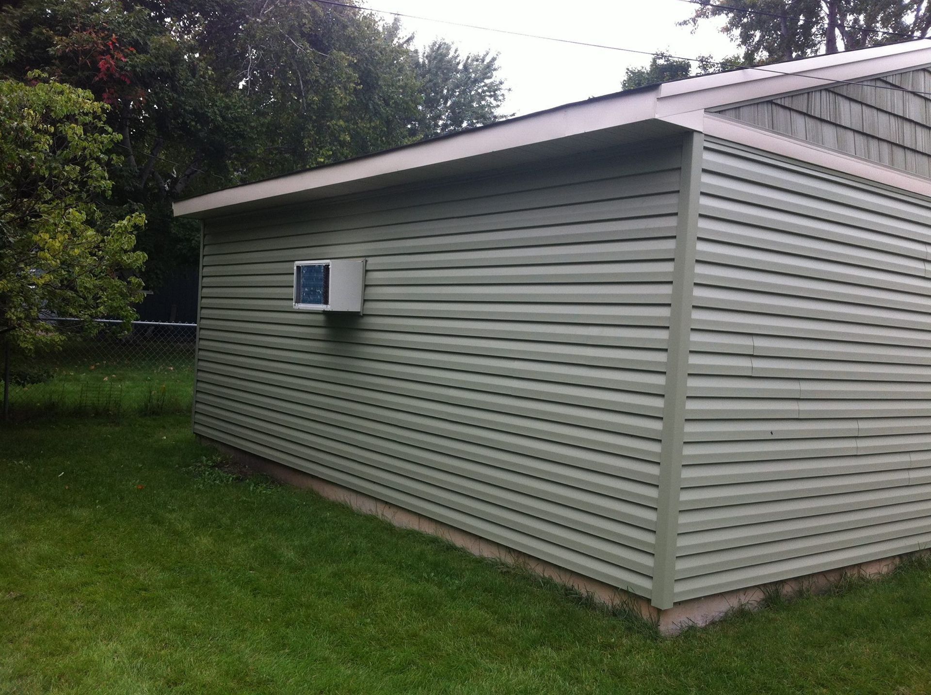 A shed with a fan on the side of it