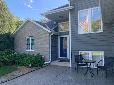 A house with a table and chairs in front of it.