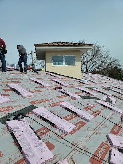 Two men are working on the roof of a house.
