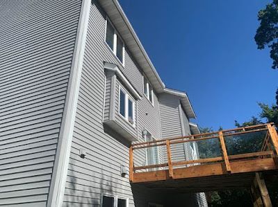 A large house with a wooden deck on the back of it.
