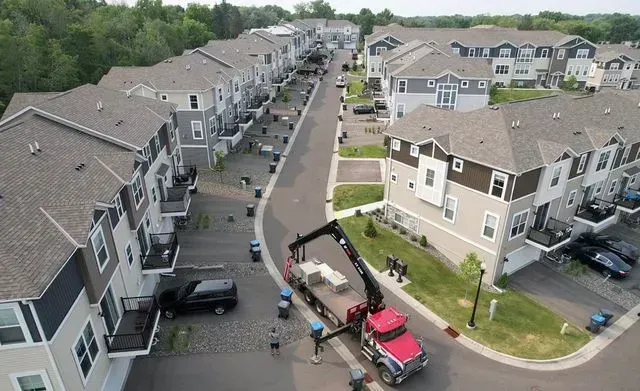 An aerial view of a residential area with a red truck in the middle.