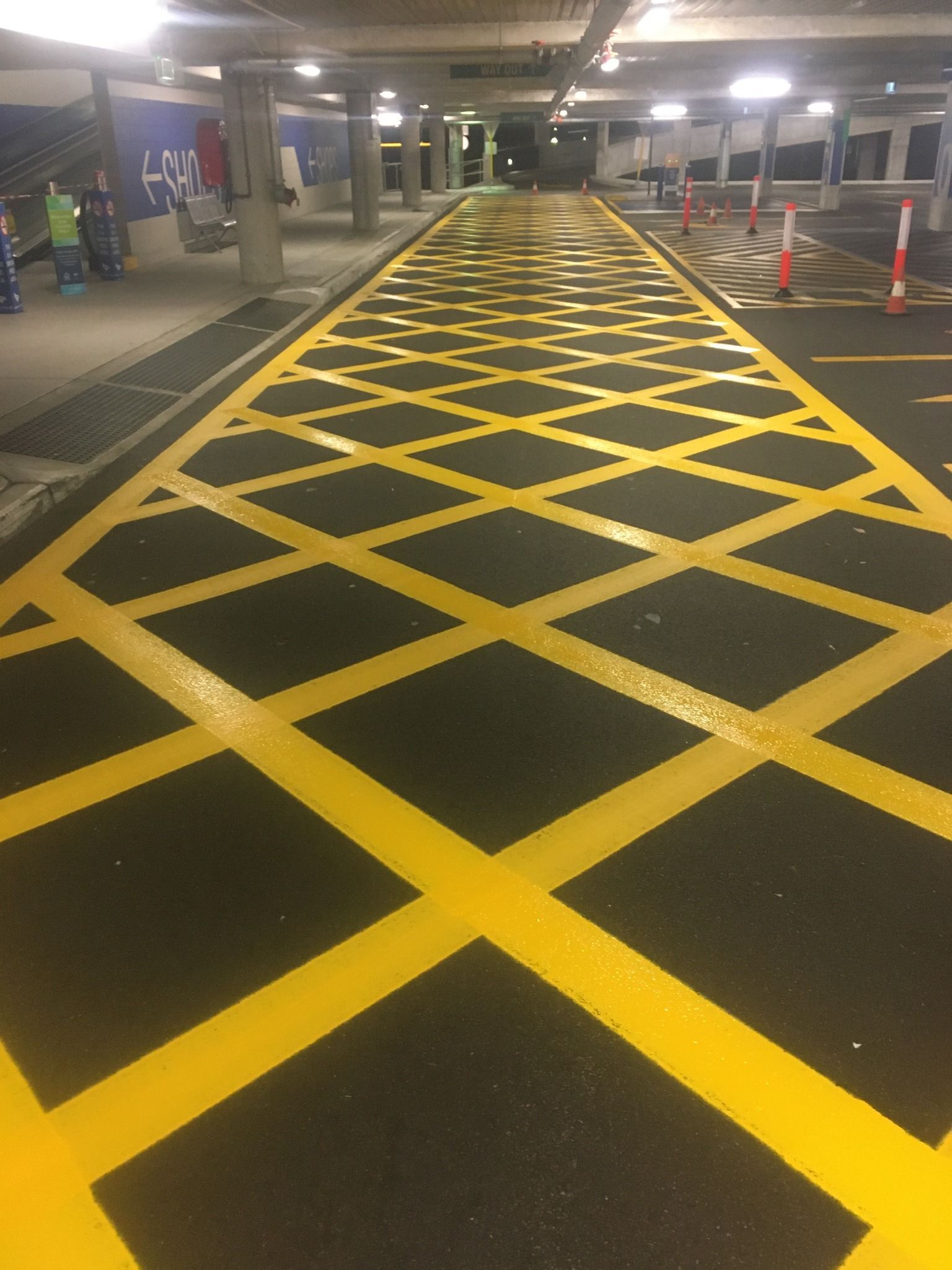 Yellow cross-hatched pavement markings in a parking garage.
