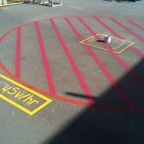 Red and yellow radiation hazard markings on asphalt, including 