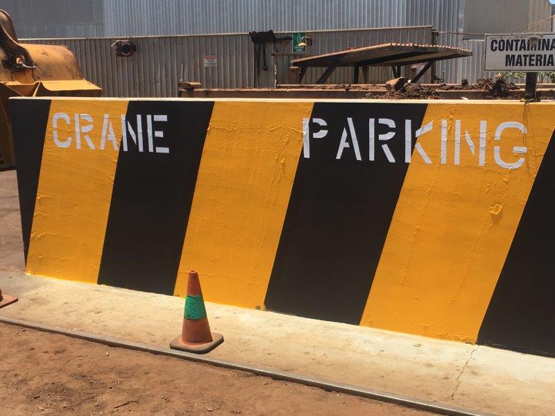 Yellow and black striped concrete barrier with 