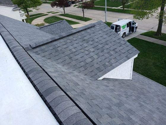 A white van is parked on the roof of a house.