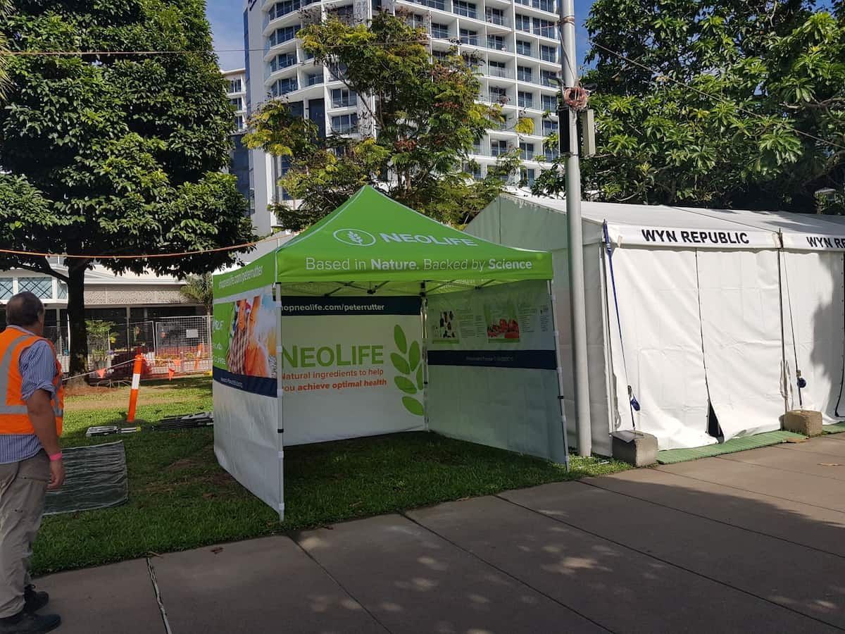 A Man In An Orange Vest Is Standing Next To A Green And White Tent — Vibrant Health - Vibrant Life In Yorkeys Knob, QLD