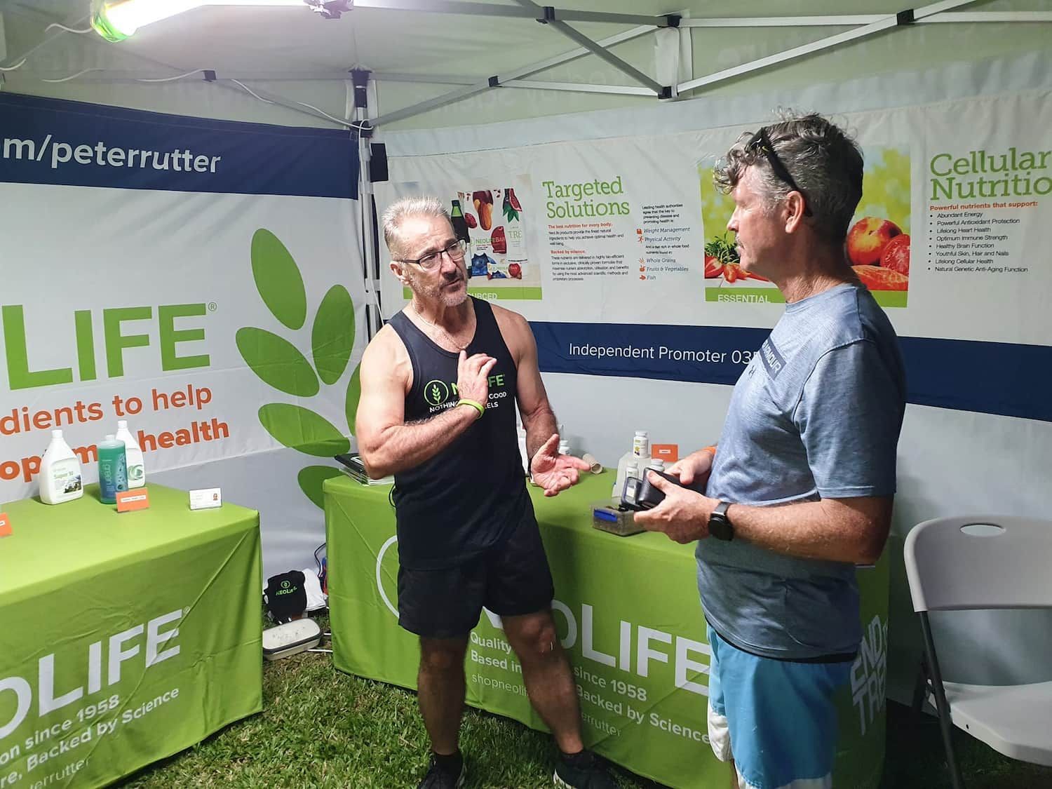 Two Men Are Standing In Front Of A Table That Says Life On It — Vibrant Health - Vibrant Life In Yorkeys Knob, QLD