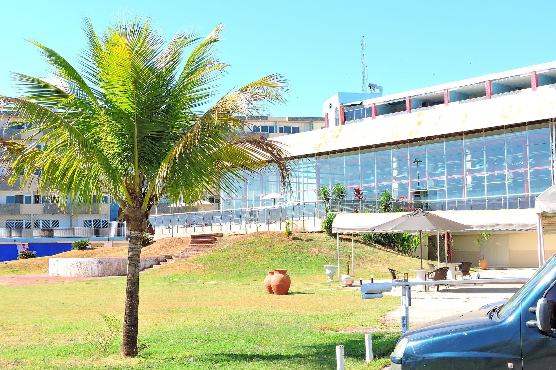 Um carro azul está estacionado em frente a um grande edifício Bay Park Hotel