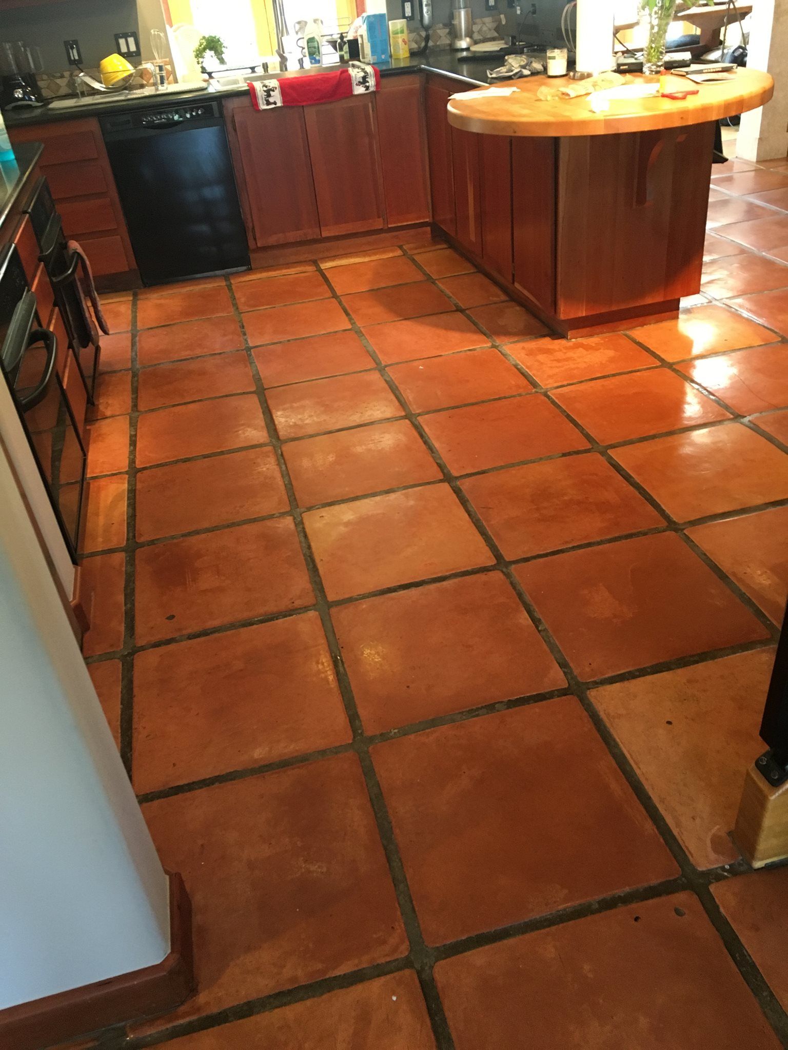 A kitchen with a tile floor and wooden cabinets