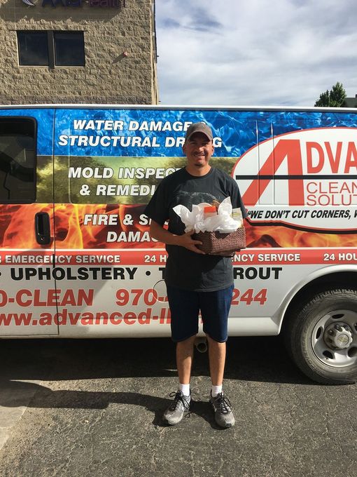 A man is standing in front of a van that says advanced clean solutions.