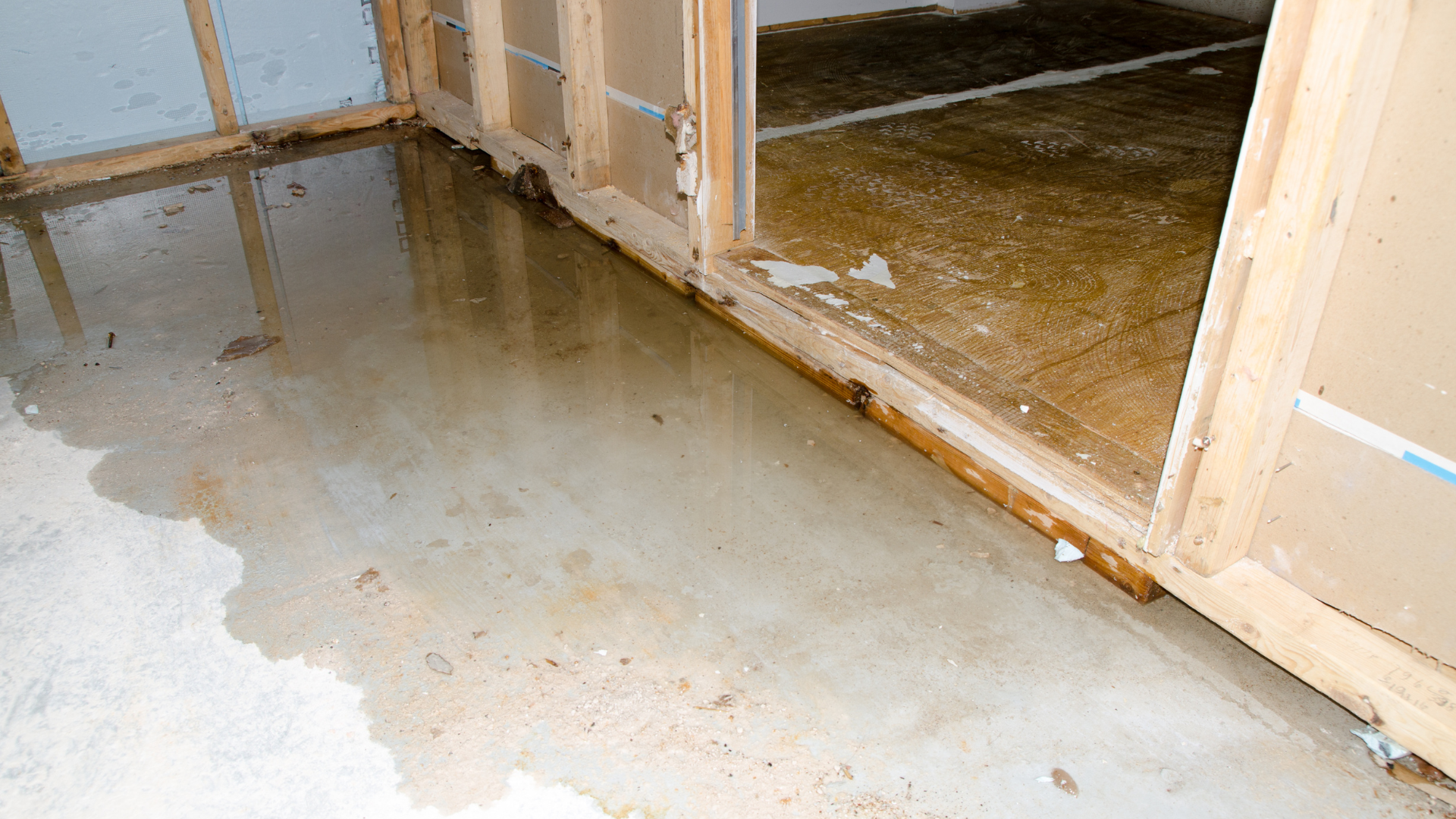 A flooded basement with a puddle of water on the floor.