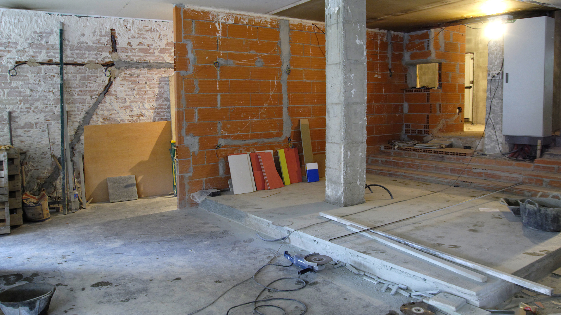 A room with brick walls and a cross on the wall.