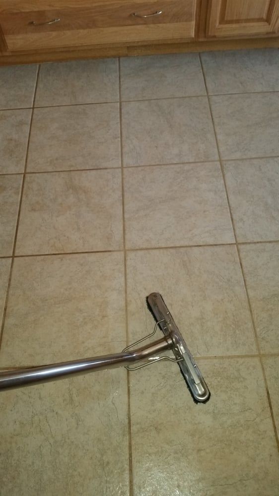 A vacuum cleaner is sitting on a tiled floor.