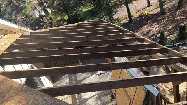 A wooden structure is being built on top of a house.