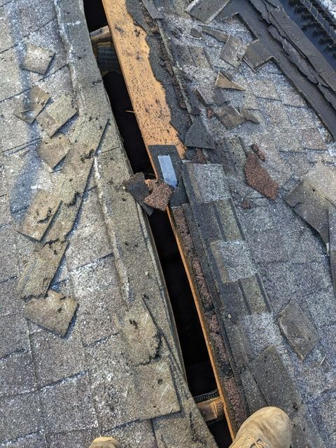 A person is standing on a roof with a hole in it.